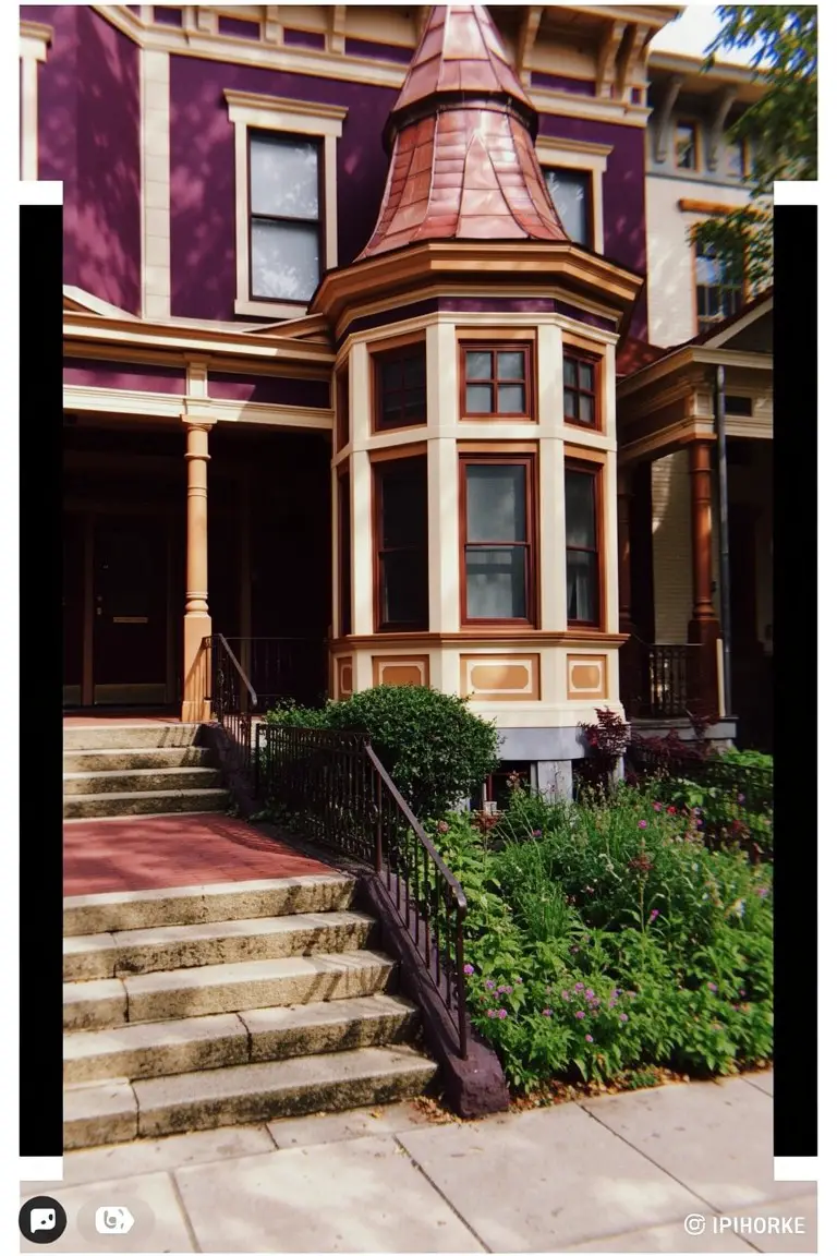 Victorian house exterior painted deep mauve with cream wood trim, copper roof accents, and brick steps