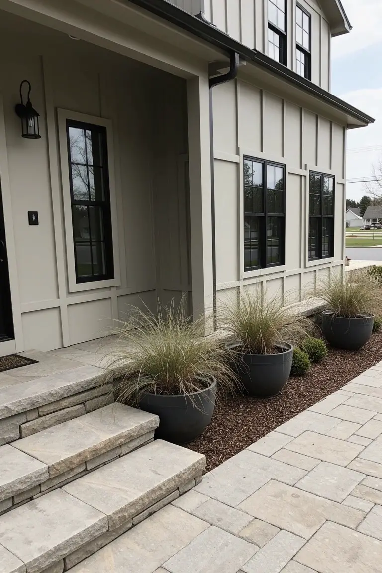 Ranch house exterior with warm greige siding, black window frames, and stone entry steps