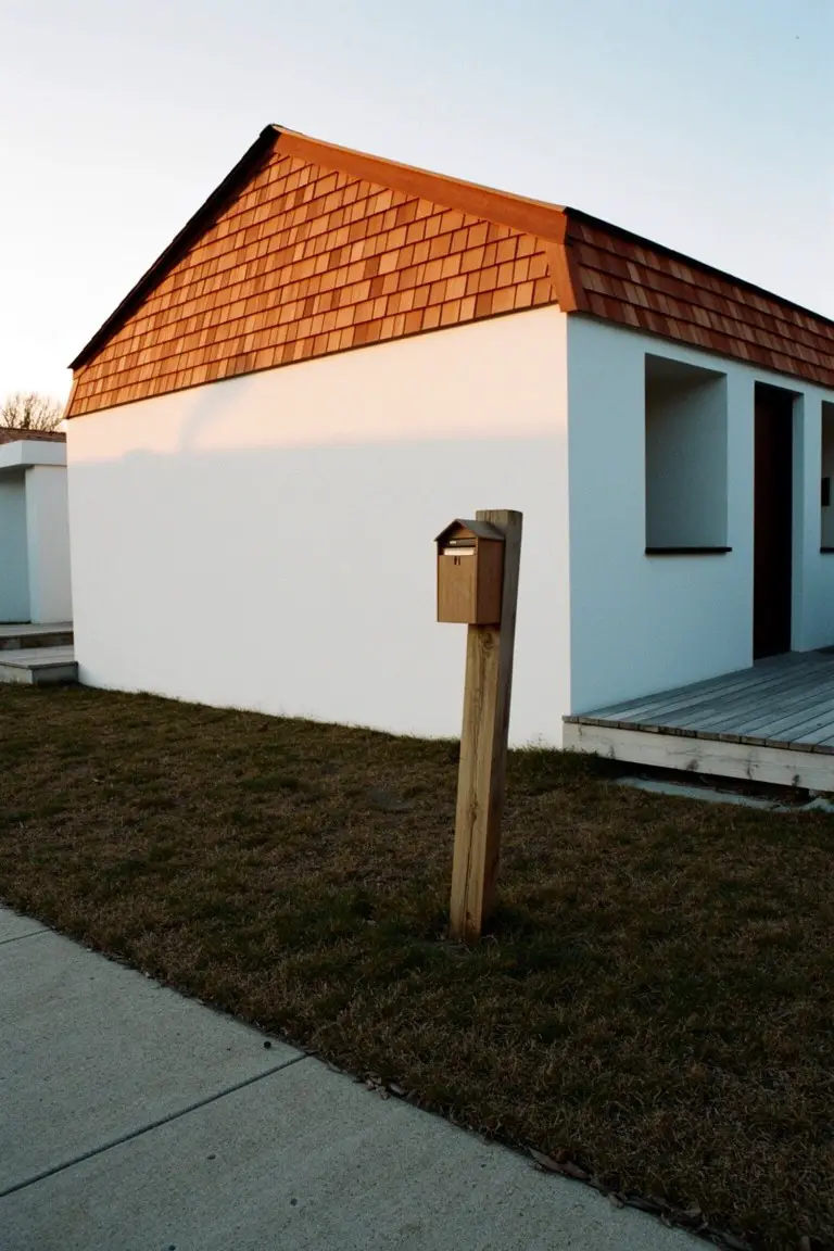Bright white exterior walls with warm terracotta roof contrast on a simple modern house