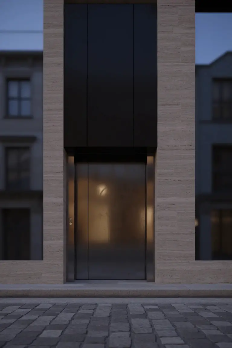 Modern facade with tall charcoal gray panels framing a beige stone building at twilight