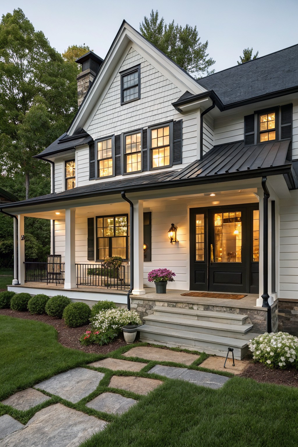 White shingled two-story house with black shutters, window frames, front door, porch posts, railings, and metal roof accents, front steps, landscaping, and stone path.