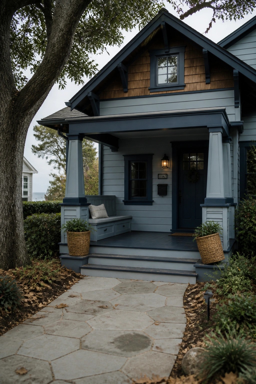 Blue-gray house with porch, steps, wicker planters, and stone pathway