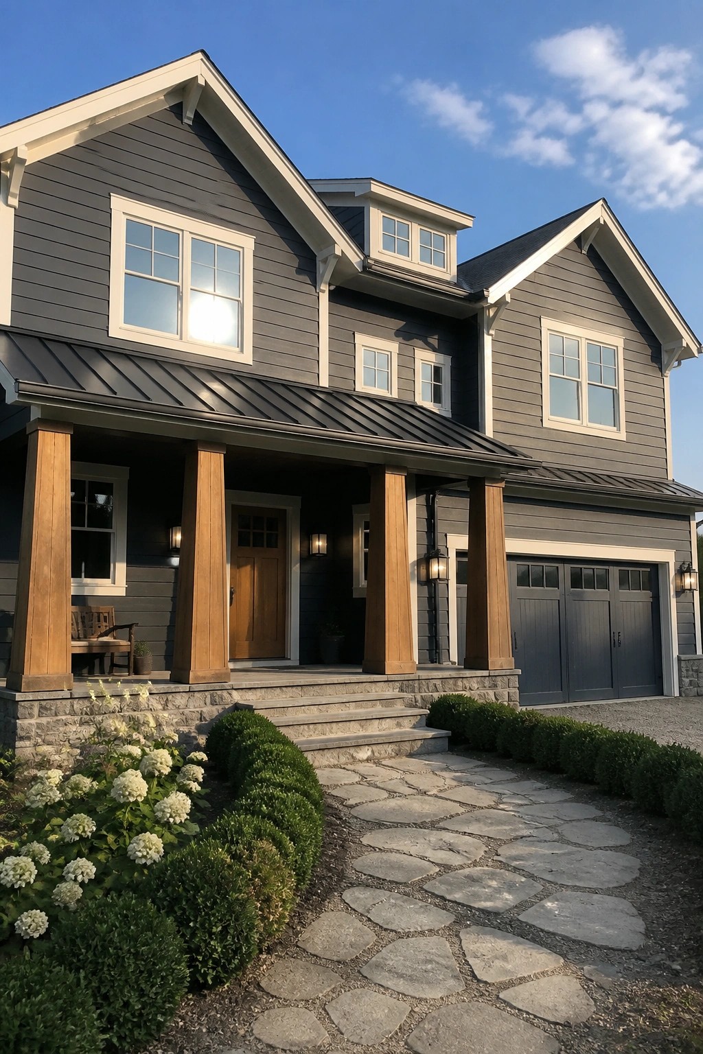 Large two-story home with dark charcoal gray siding, wood columns, and stone foundation.