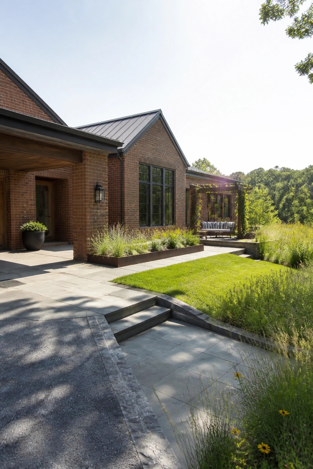 Modern brick home with stone patio, green lawn, and garden landscaping