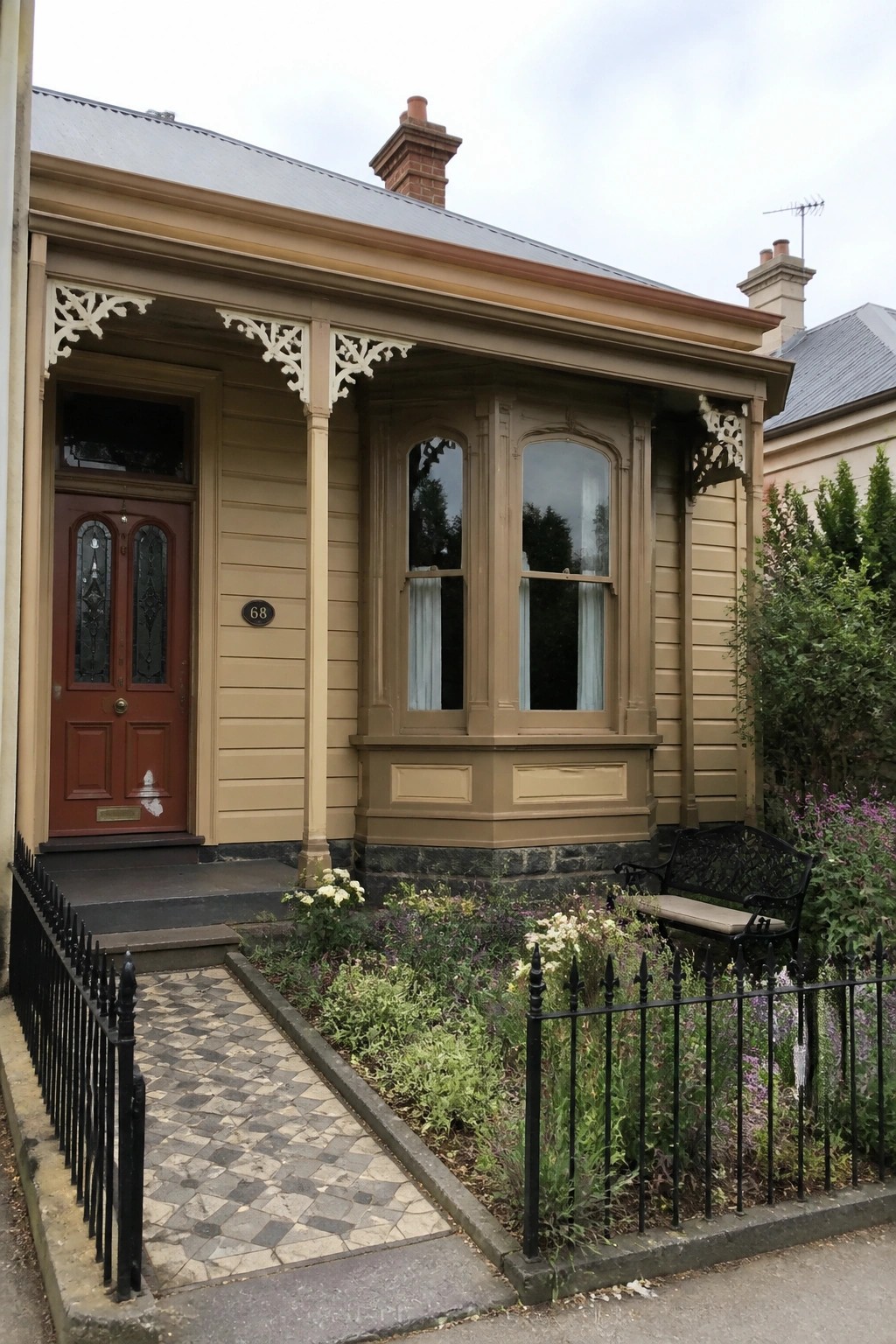 Warm beige siding on a traditional cottage with a stone foundation and bay window.