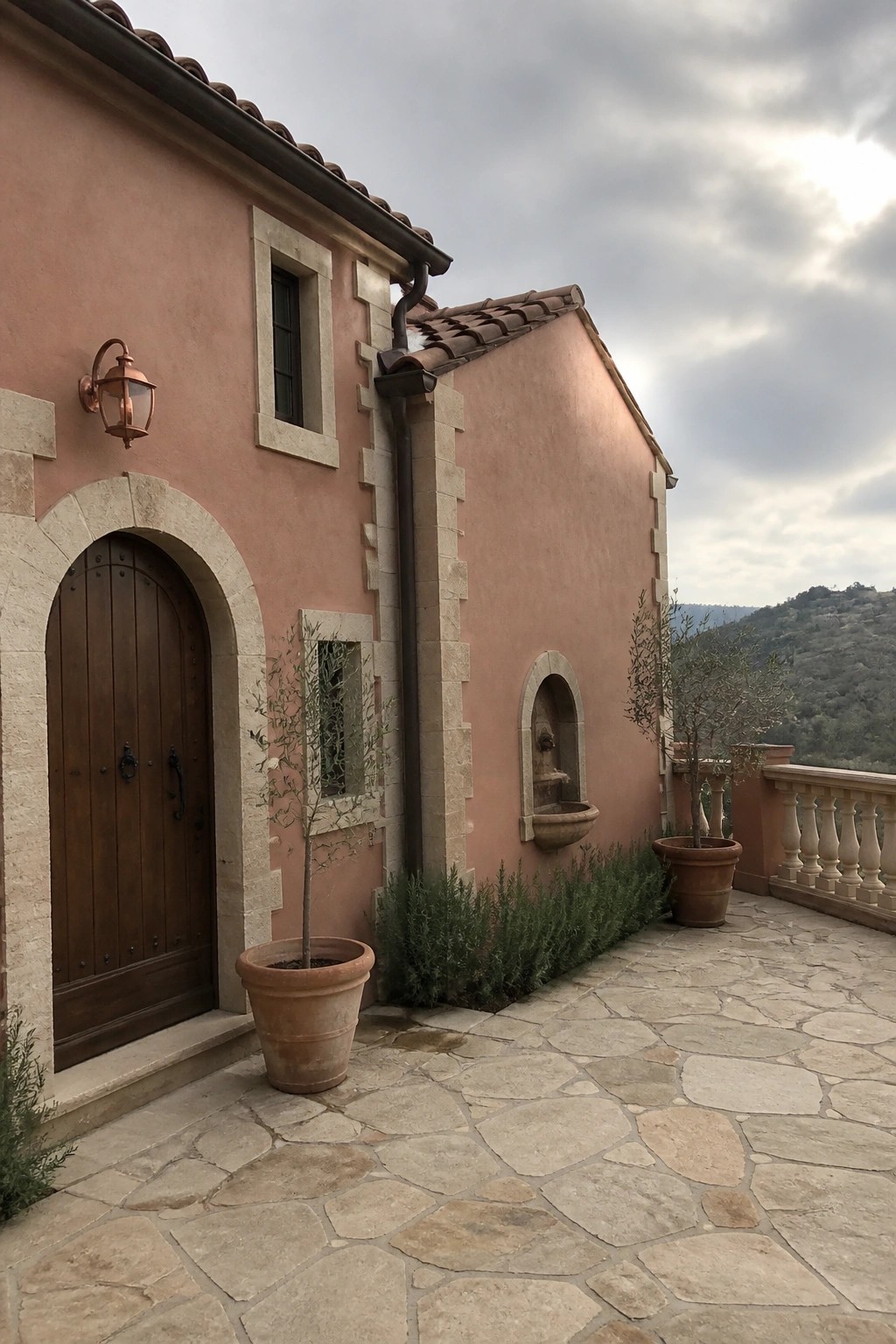 Warm terracotta stucco walls on a Mediterranean-style house exterior with stone trim.