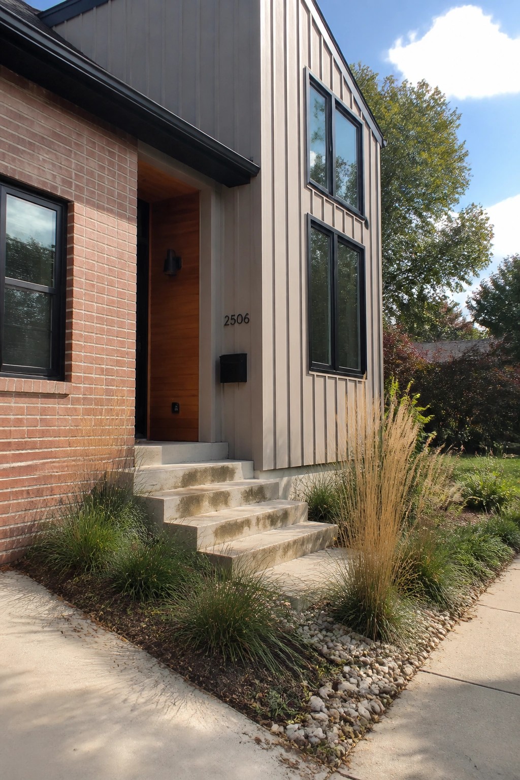 Warm greige siding on a house exterior next to red brick.