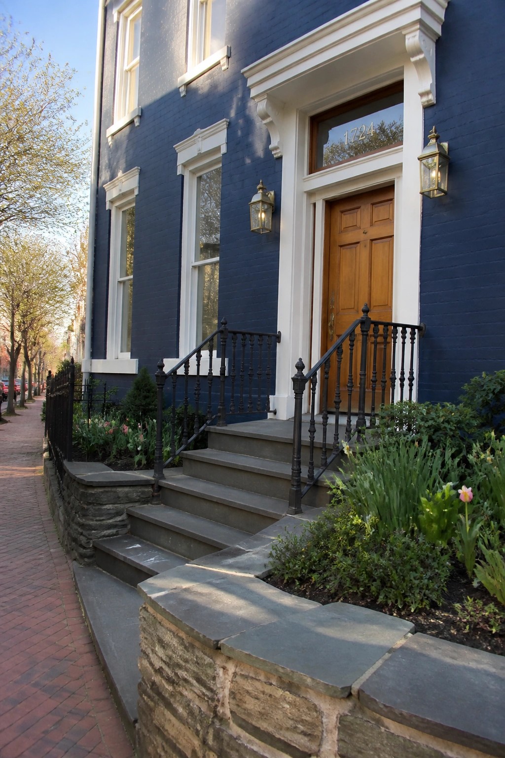 Deep navy blue house exterior with white trim and a stone foundation.