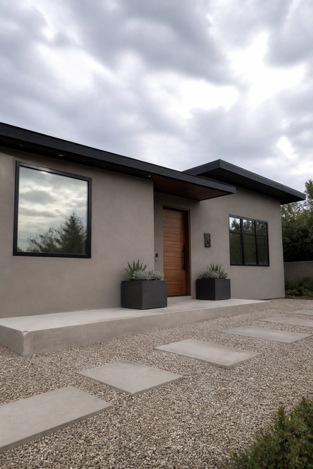 Modern stucco house painted in a warm greige with black windows and trim.