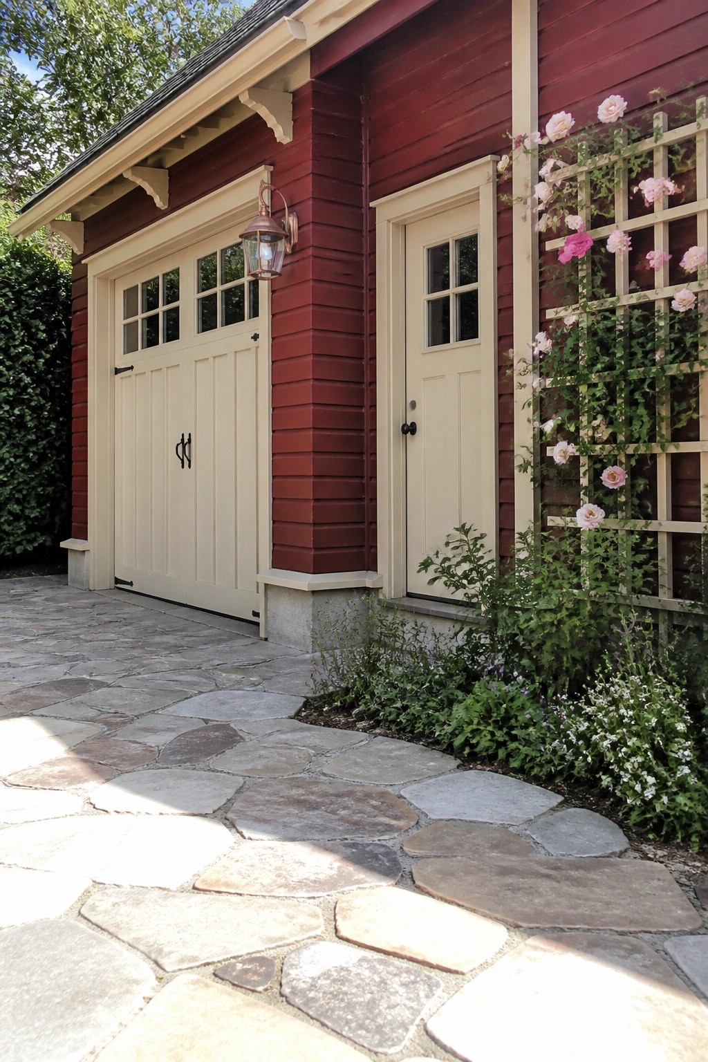Red building with cream garage doors, stone path, and rose-covered trellis