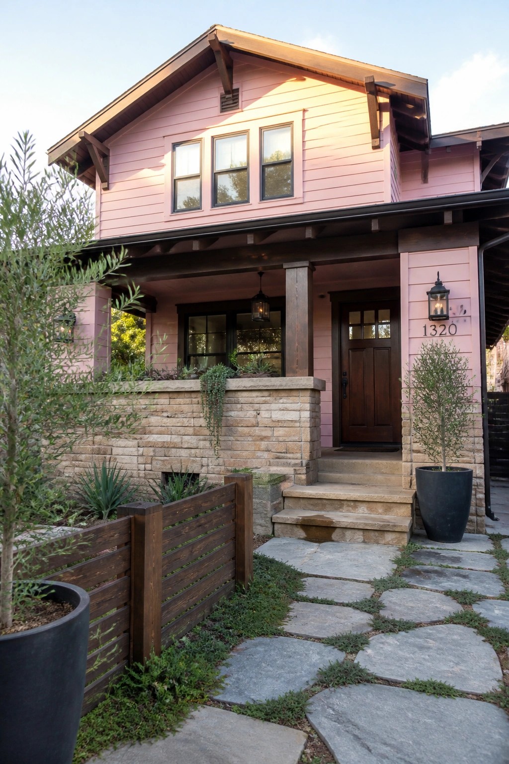 Pink two-story house with stone pathway, steps, porch, and potted plants