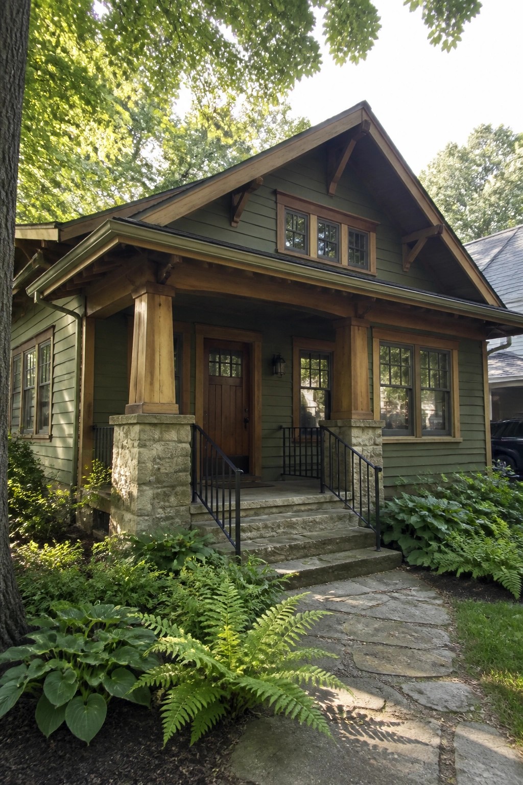 Green Craftsman bungalow with stone steps, wooden porch columns, and fern garden.
