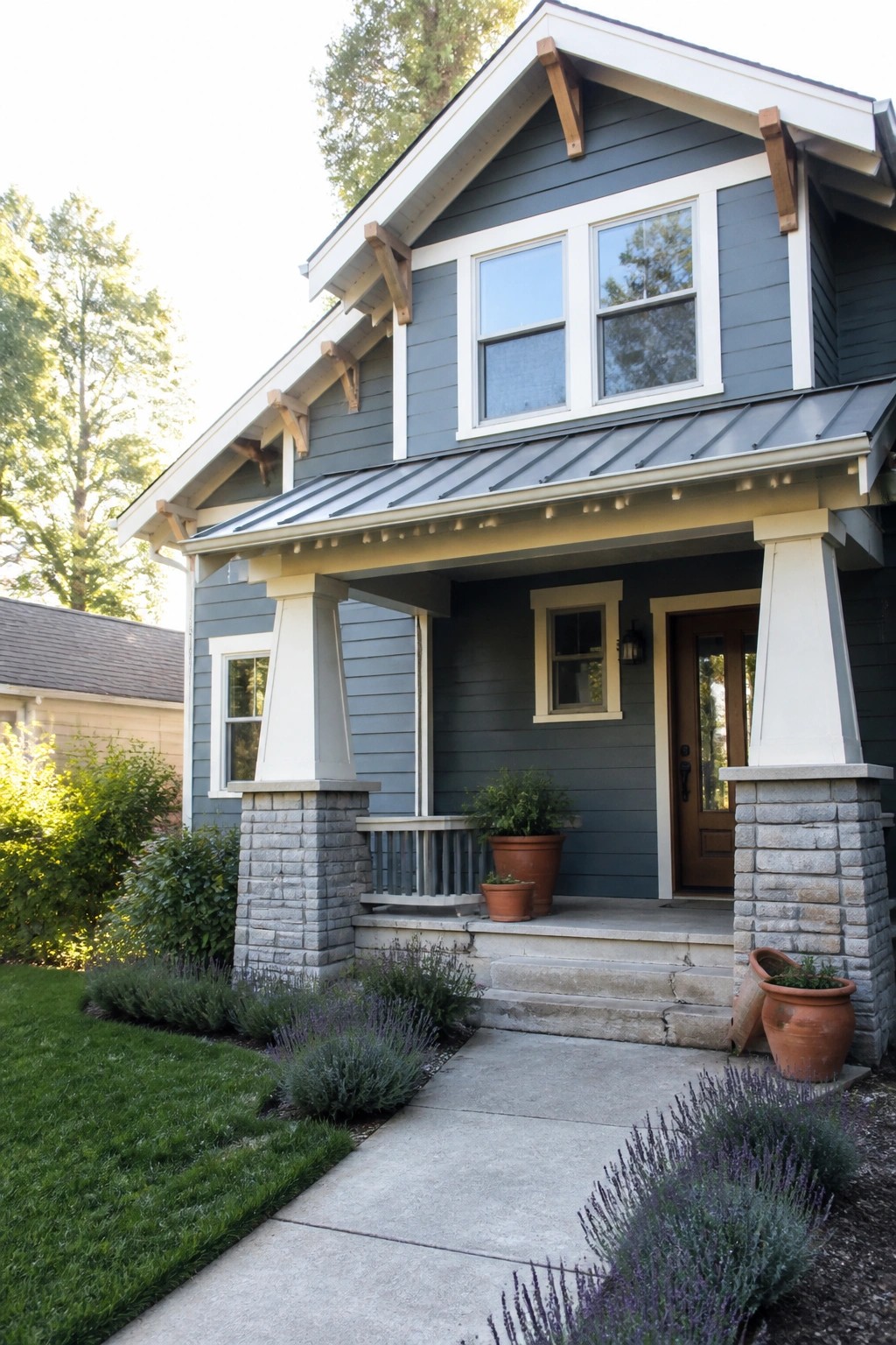 A Craftsman house exterior with slate blue siding, white trim, and stone porch pillars.