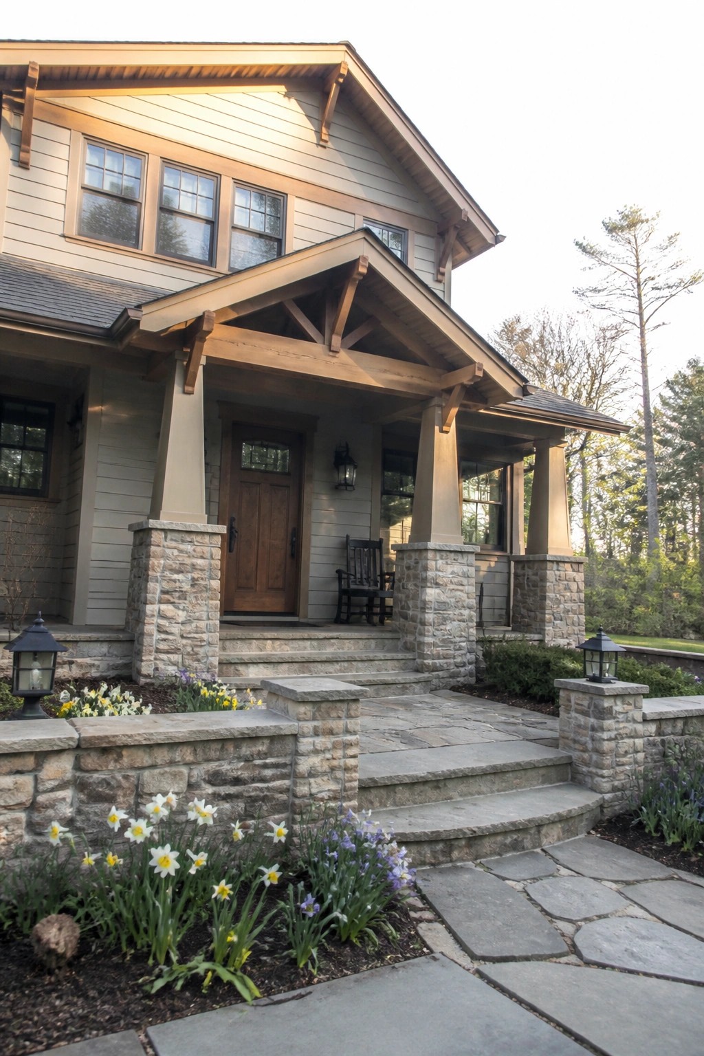 A Craftsman house with warm beige siding, wood trim, and stone porch columns.