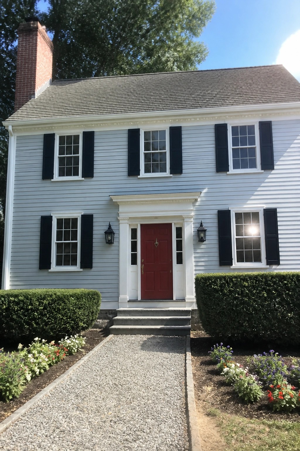 A two-story house with light blue-gray siding and white trim.