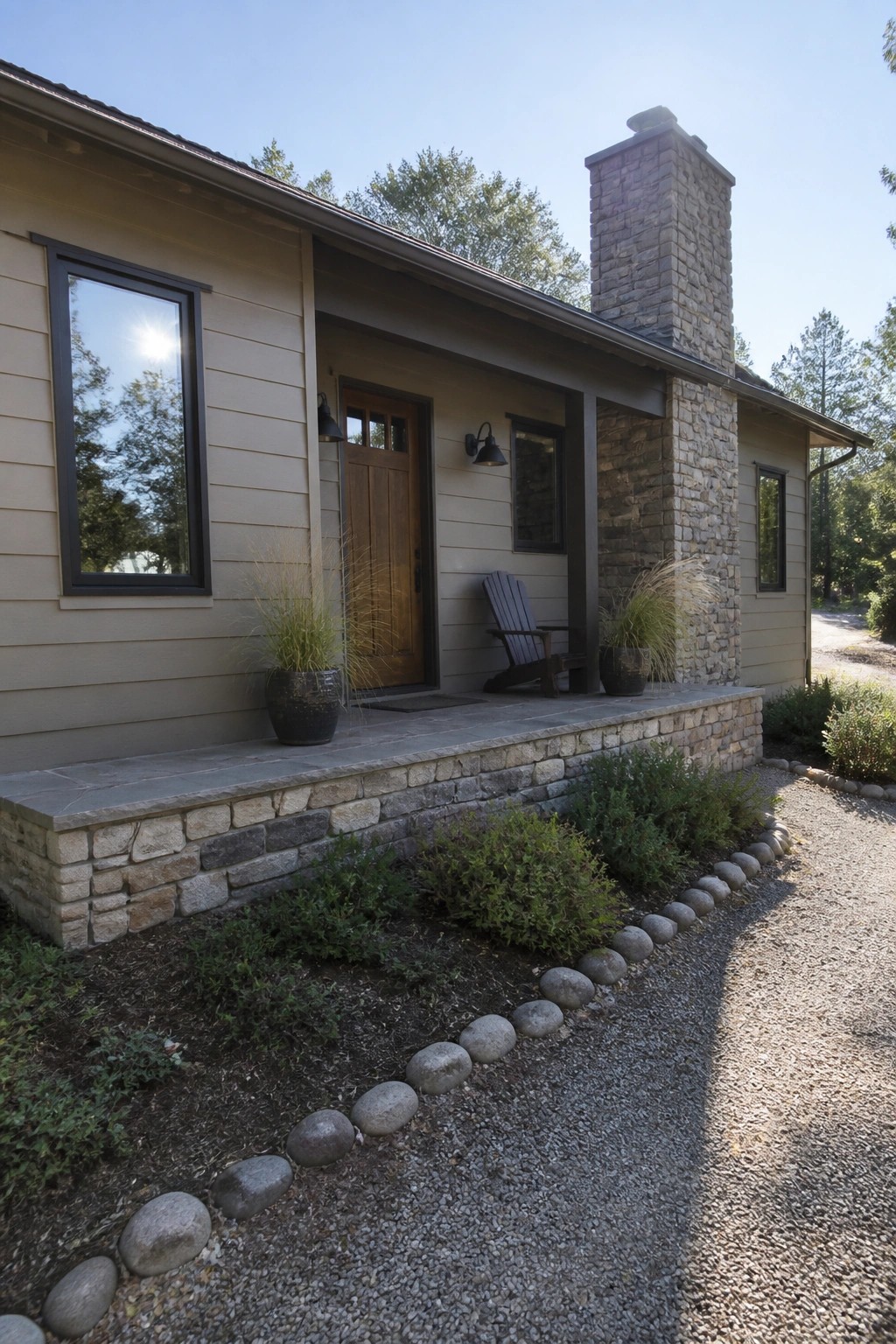 House exterior with warm greige siding and natural stone chimney and foundation.