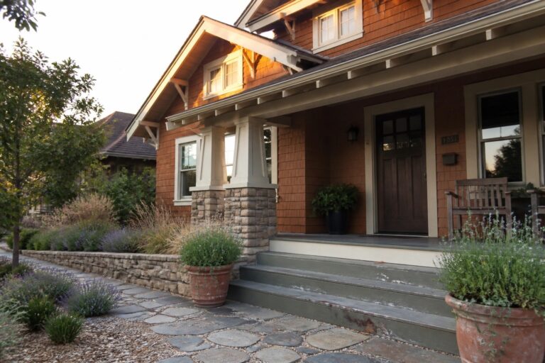18 Classic Orange Craftsman House Exteriors Featuring Shingle Siding Craftsman house porch with stone pillars, wooden siding, steps, and flagstone path at sunset