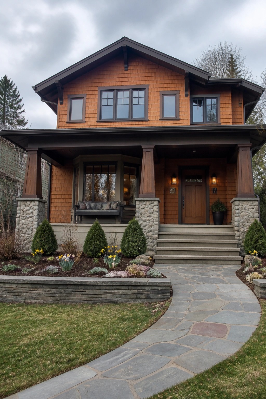 Two-story orange wooden house with stone porch, steps, and curving stone path