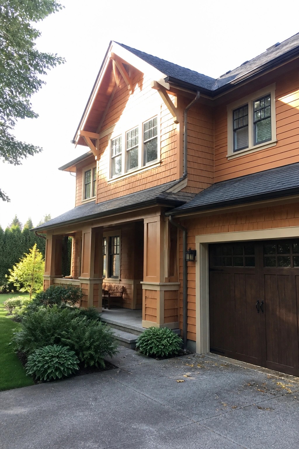 A two-story orange Craftsman house with shingle siding, a covered front porch, and an attached garage with dark wood doors.