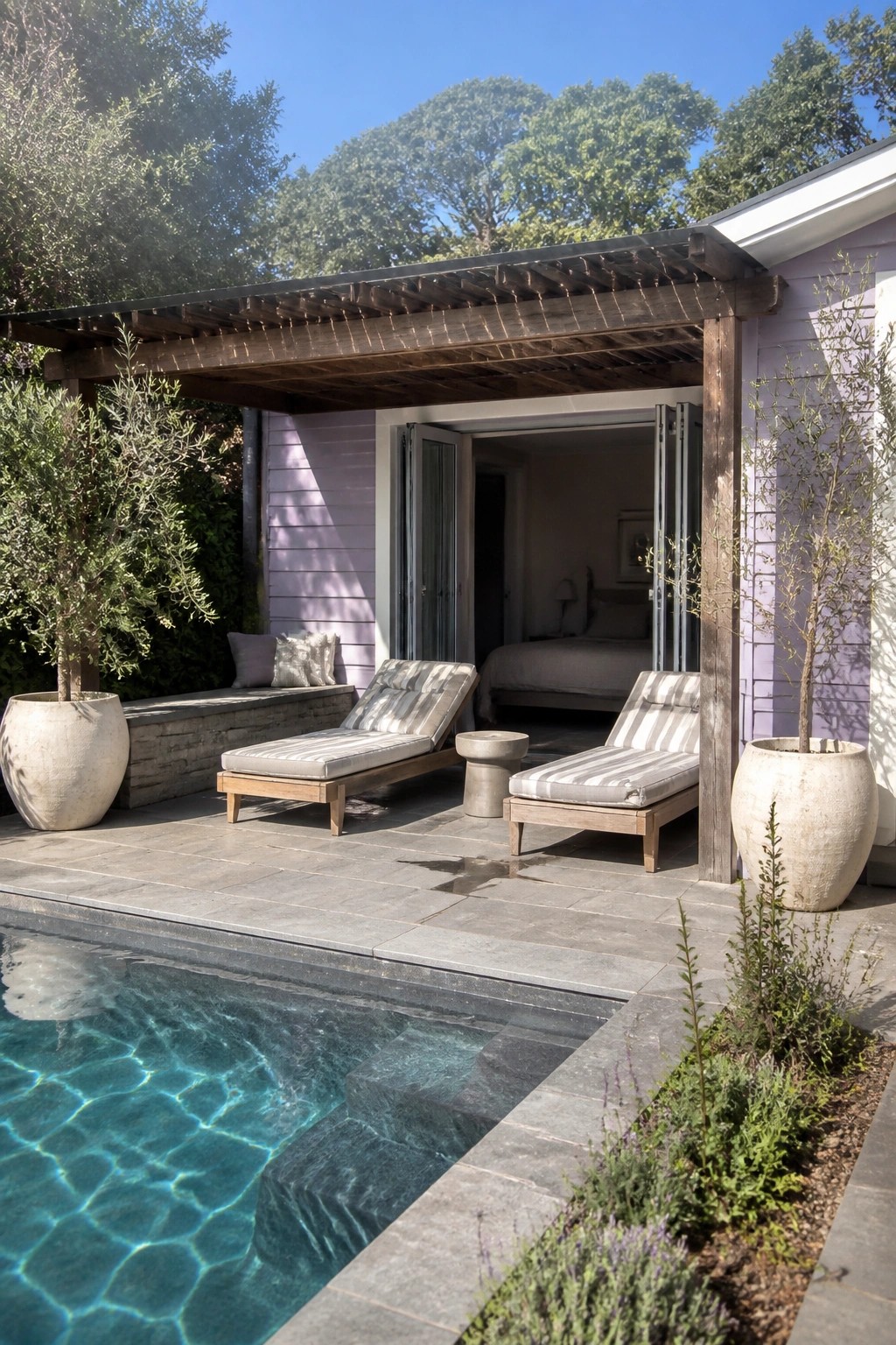 Light purple horizontal lap siding on a house exterior with a covered patio, two striped lounge chairs, and a swimming pool in the foreground.