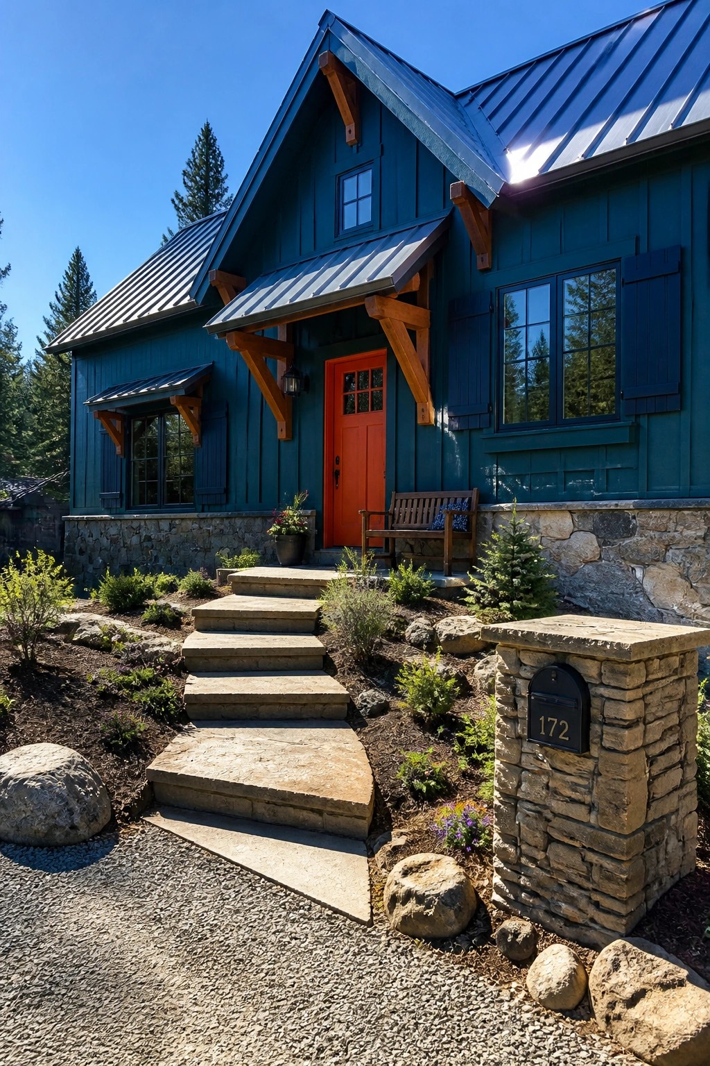 A teal blue house exterior with an orange front door, navy shutters, stone foundation, and a set of concrete steps leading to the entrance.