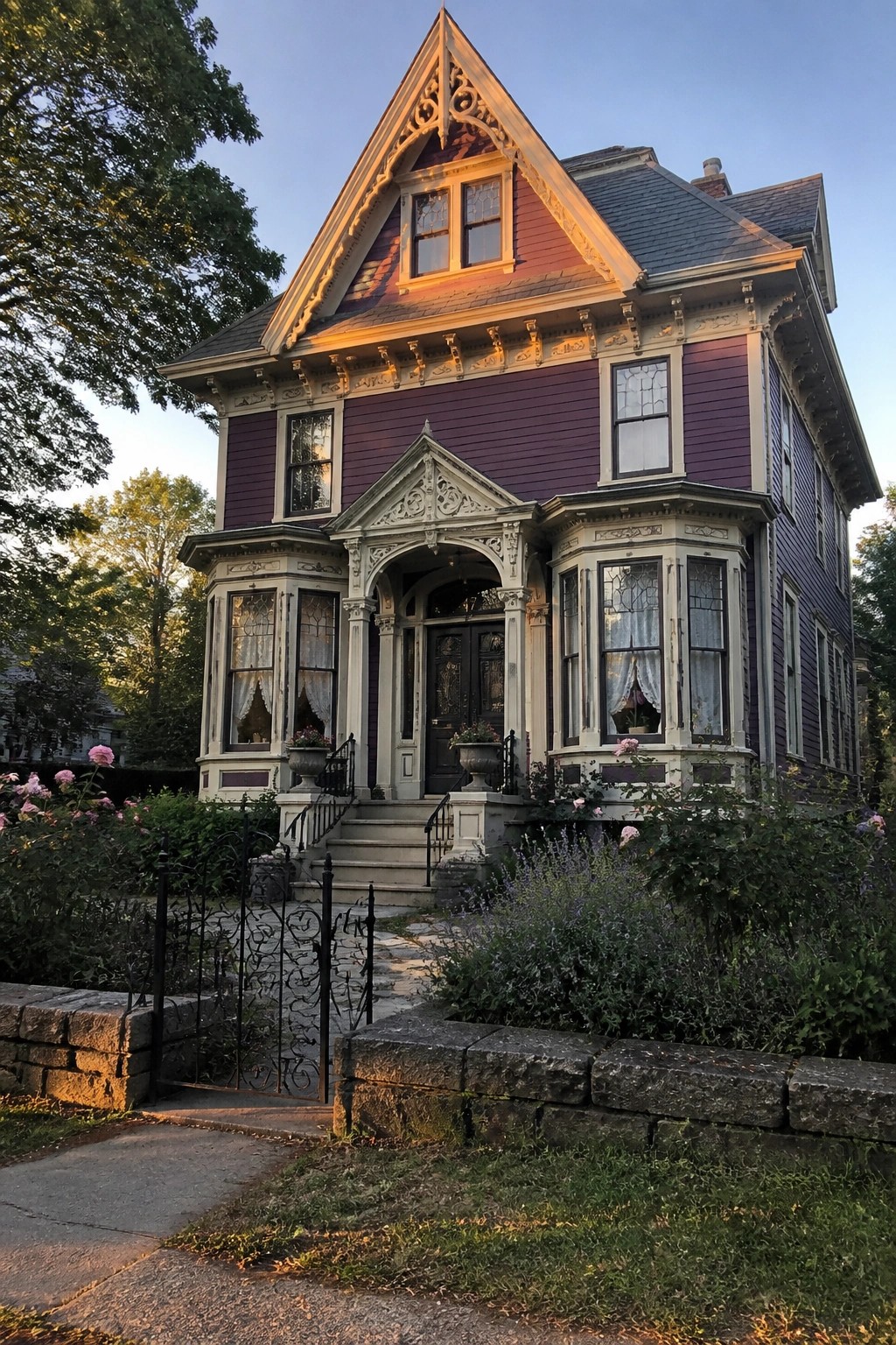 Purple Victorian house with ornate white trim, red roof, and lush garden.