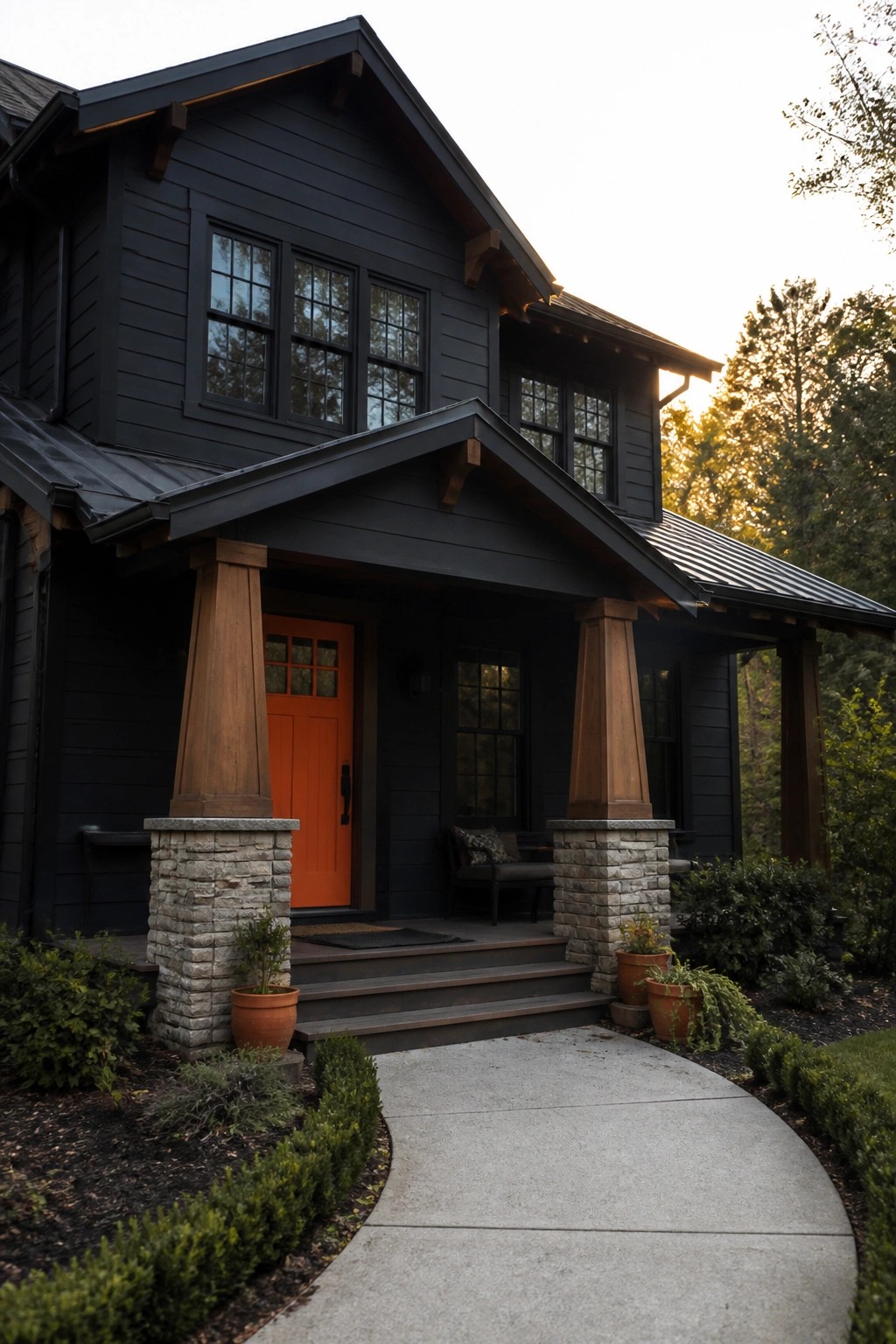 Dark modern house with bright orange door, wooden pillars, and stone bases