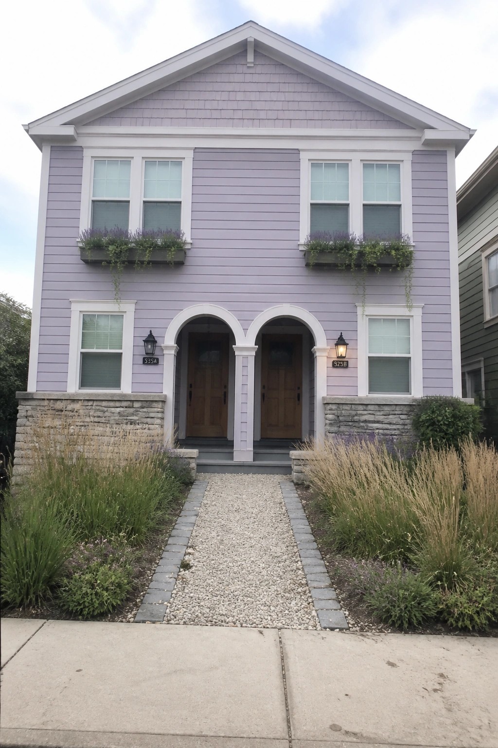 Light purple two-story home with twin arched doorways and flower boxes
