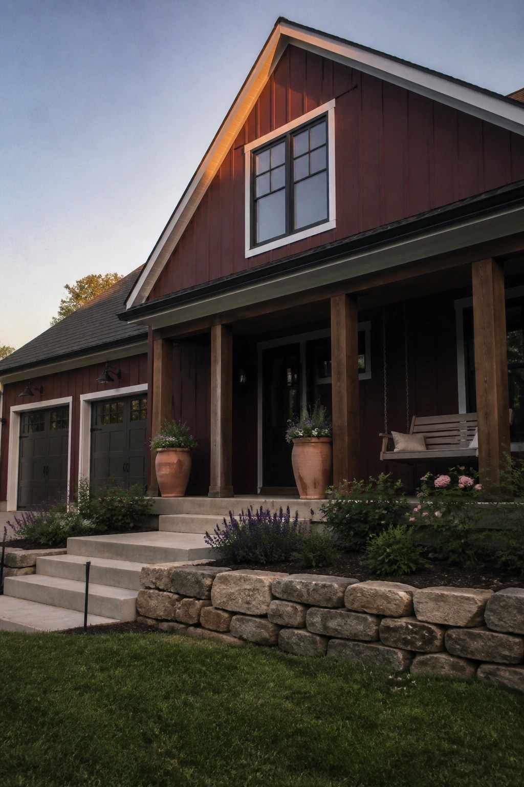 A burgundy house with smooth fiber cement siding, a gable roof, a front porch with wooden posts, and concrete steps leading to the entrance.