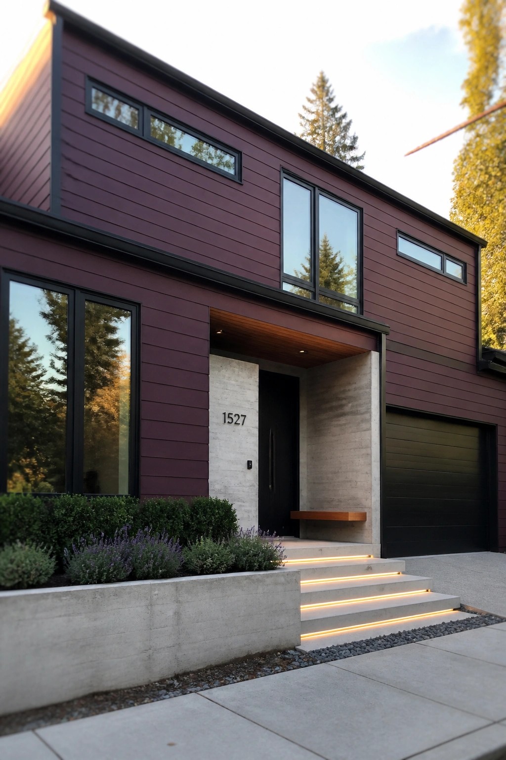 Modern maroon house with black windows, lit concrete steps, and dark garage.