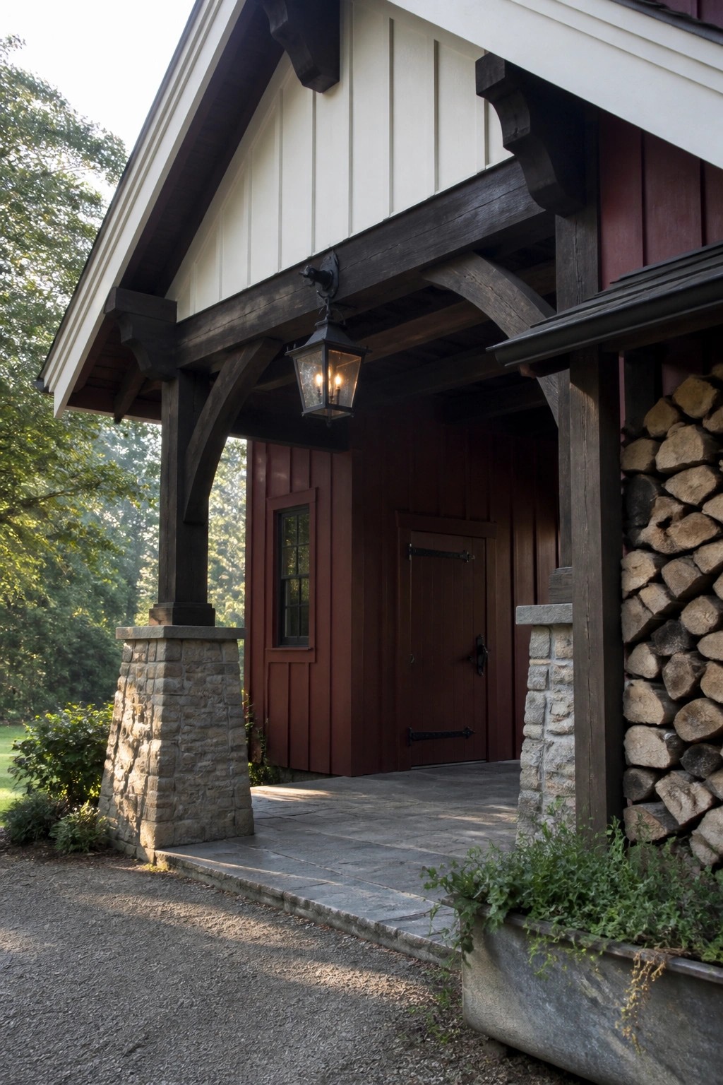 Rustic porch with dark wood beams, stone pillars, lit lantern, red door, and firewood.