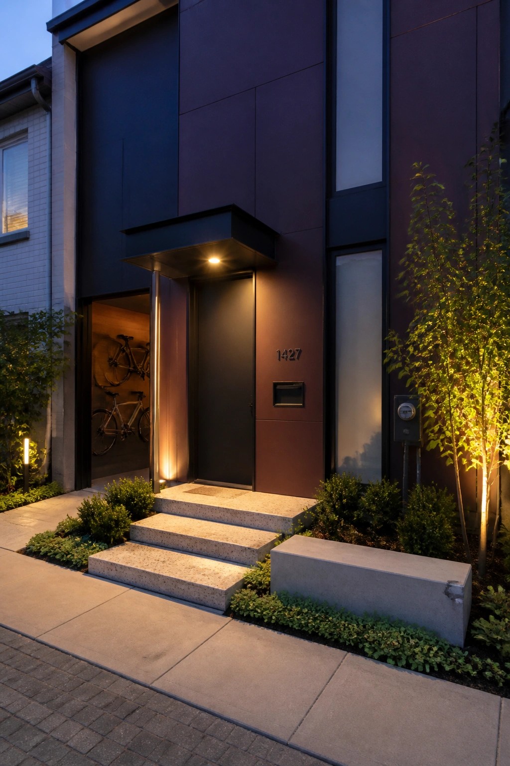 Modern house exterior with aubergine siding, a dark front door, concrete steps, and a lit entry overhang.
