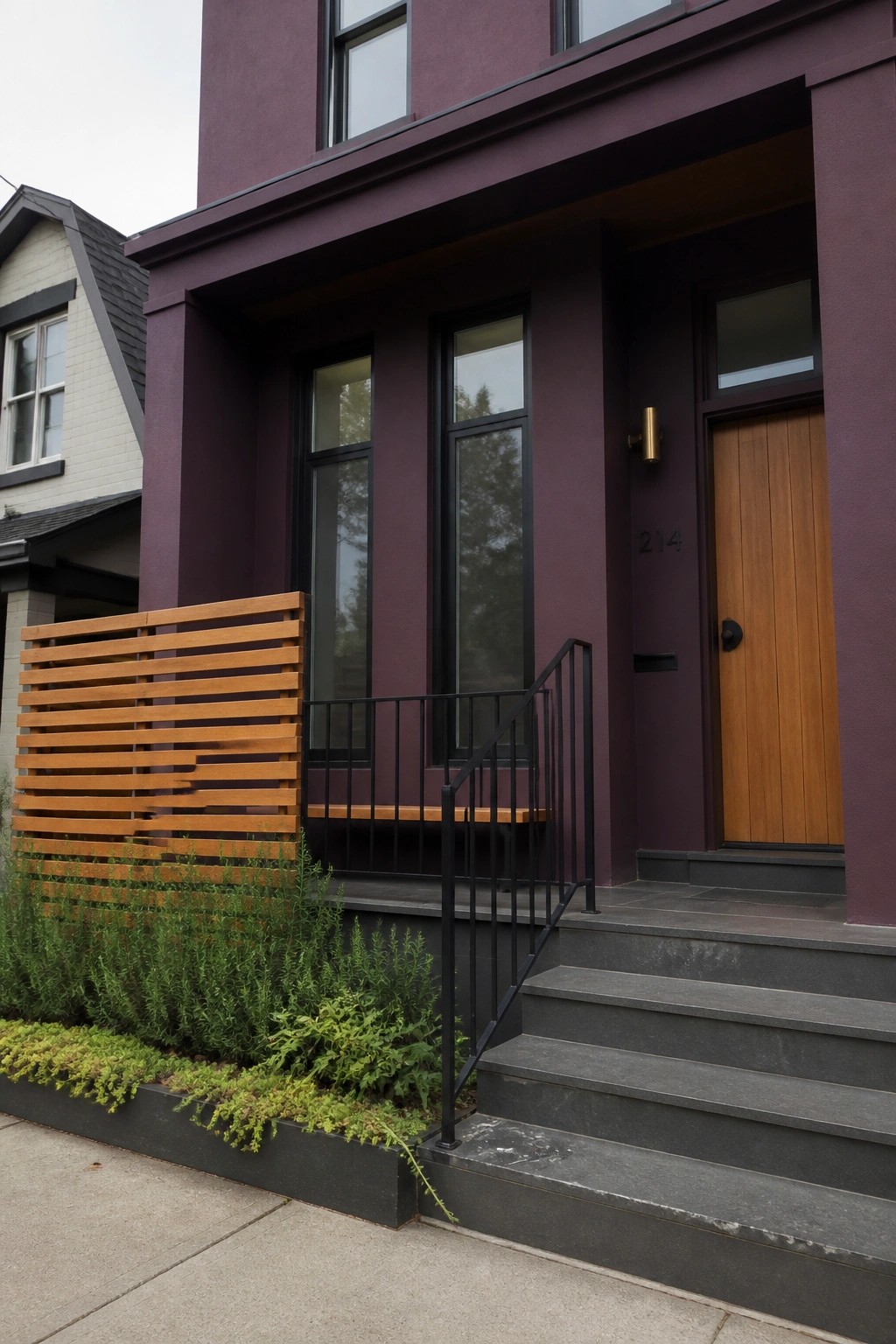 A deep purple house exterior with a wooden front door, black-framed windows, a horizontal wooden slat screen, and dark concrete steps with a black metal railing.