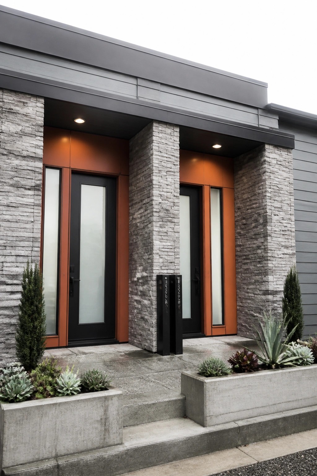 Modern entrance with twin black doors in orange frames, stone pillars, and succulent planters.
