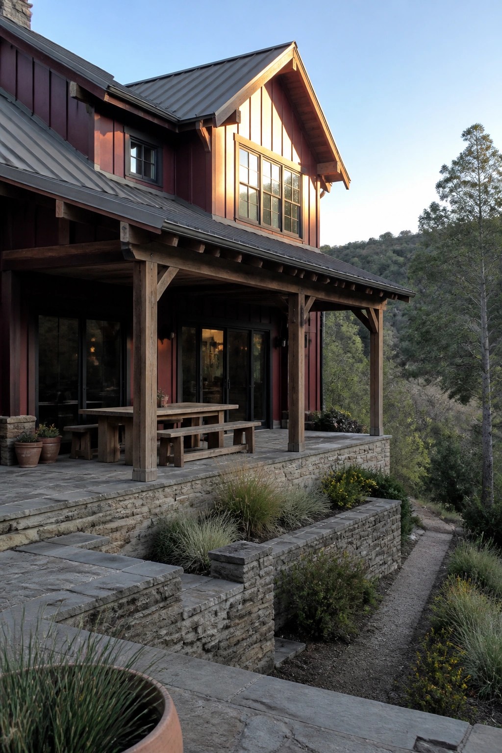 Rustic red wooden house with timber porch, stone patio, and hillside forest view