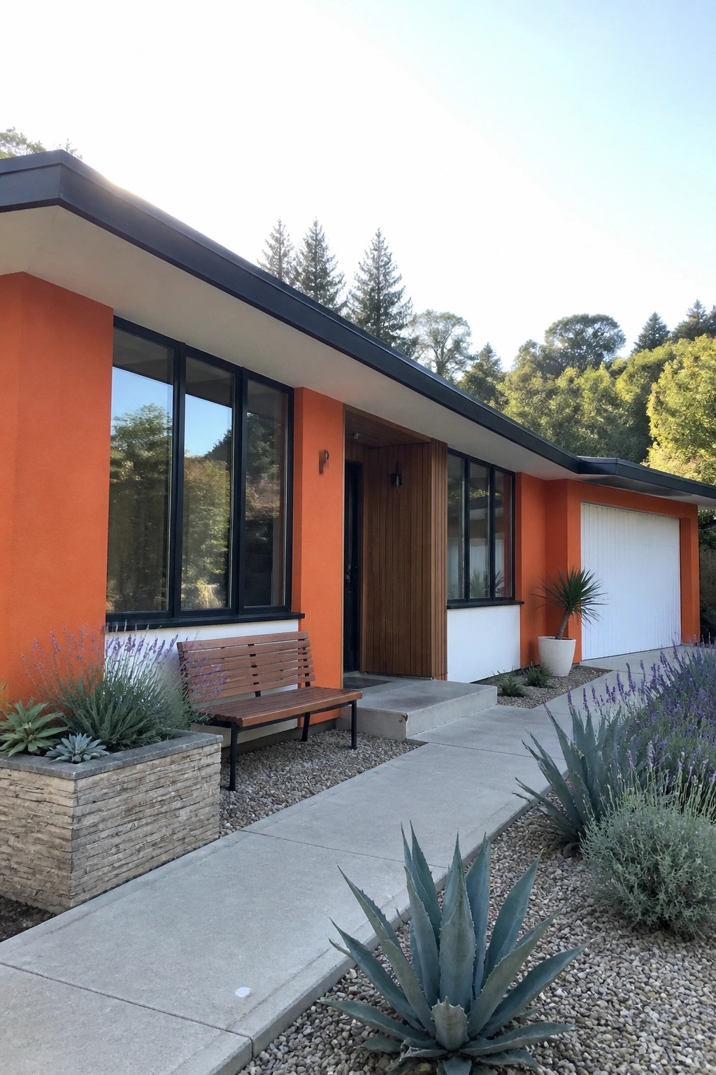 A modern single-story house with bright orange exterior walls, black window frames, a flat black roof edge, white garage door, and concrete steps leading to a wooden front door.