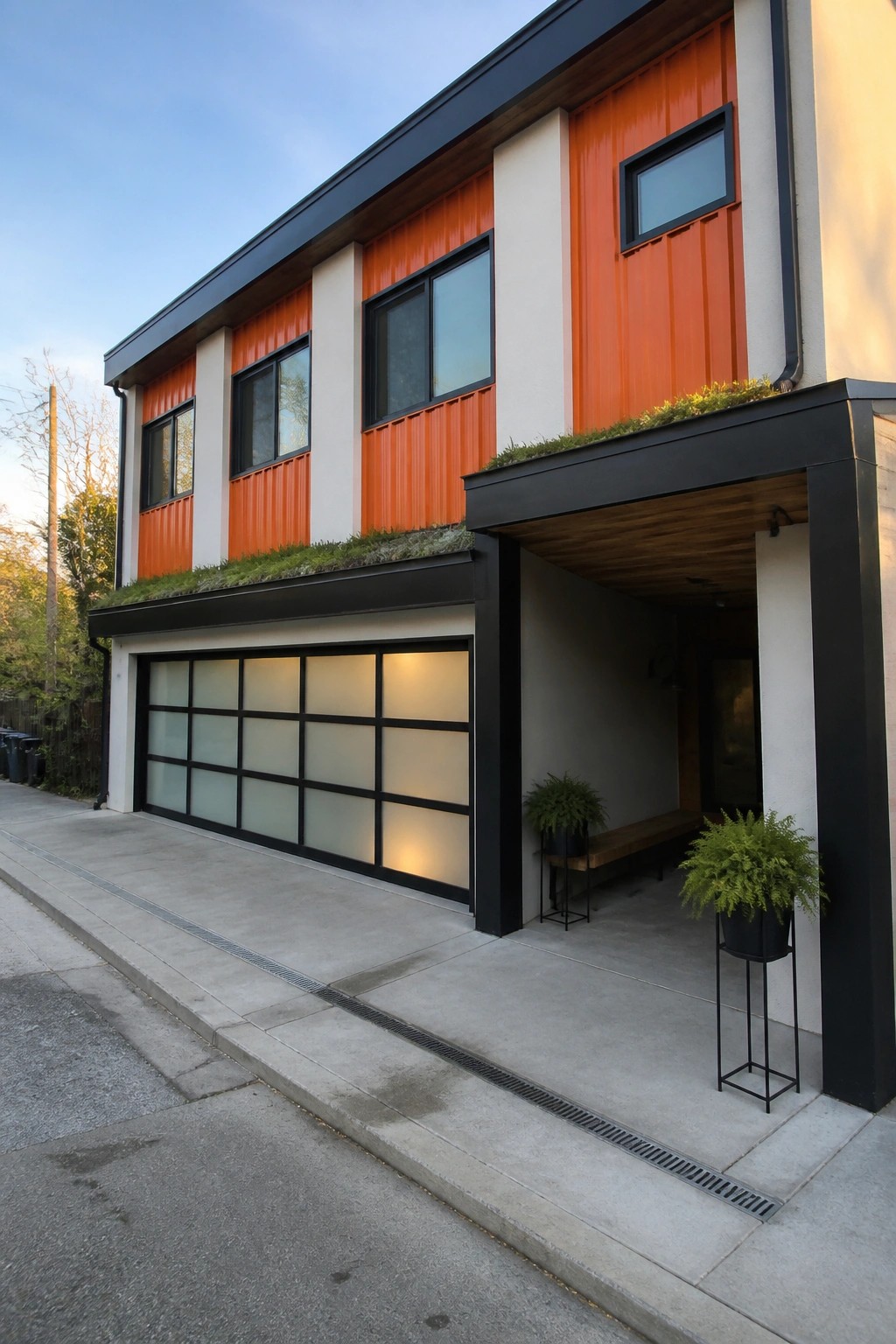 A two-story modern house with bright orange corrugated siding, white panels, and black trim around windows and the garage door, viewed from the street.