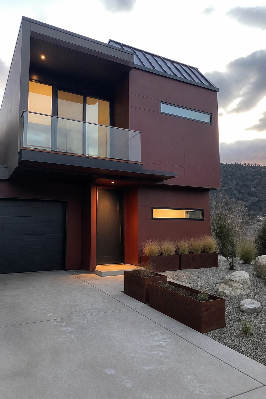 Modern two-story house with burgundy siding, black garage, glass balcony, and rusted planters.