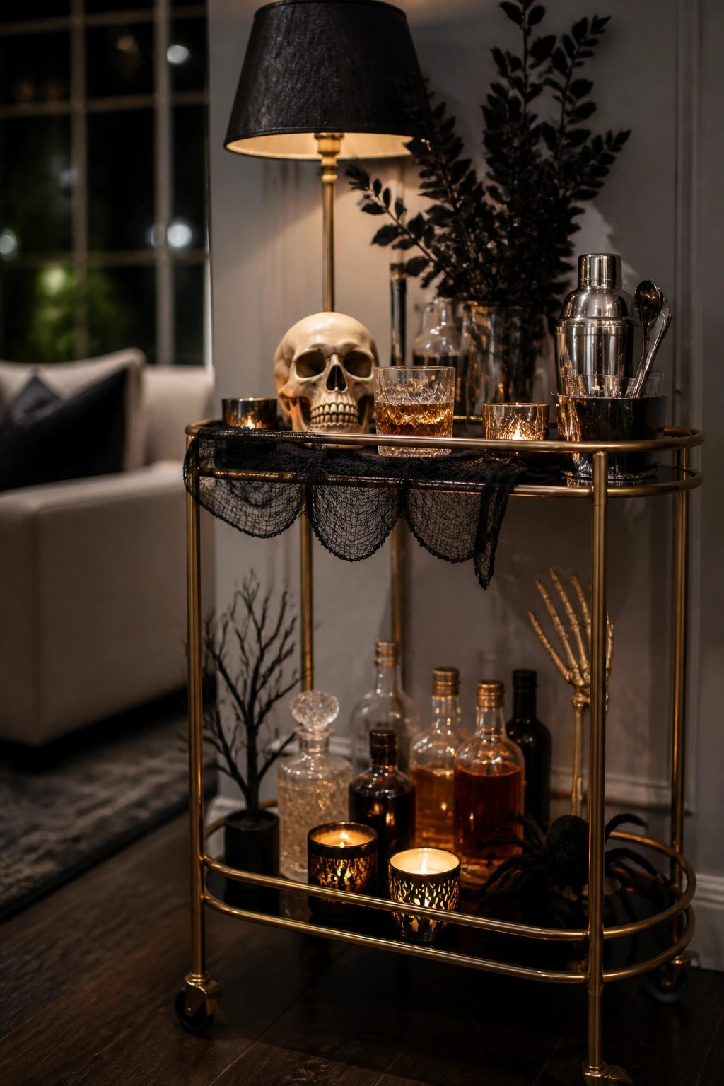 Gold bar cart with skull, black lace, liquor bottles, candles, and spiders.
