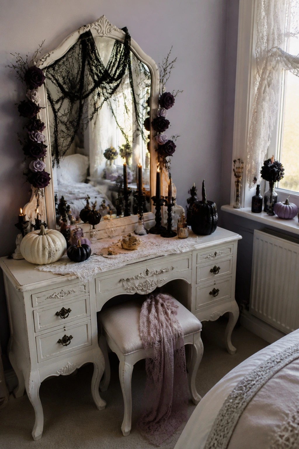 White vanity mirror in a bedroom framed with black spiderwebs, dark purple and black flowers, and black candelabras holding lit candles.
