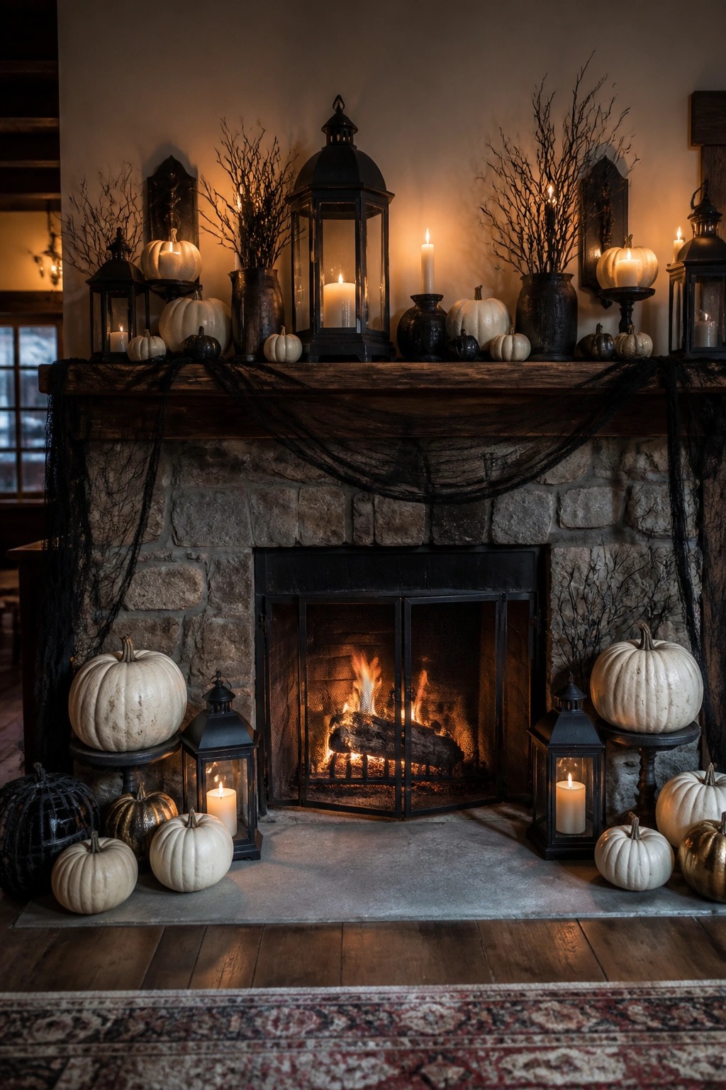 Stone fireplace mantel decorated for Halloween with black branches in vases, black lanterns, white pumpkins, and black fabric draped across the wood mantel.