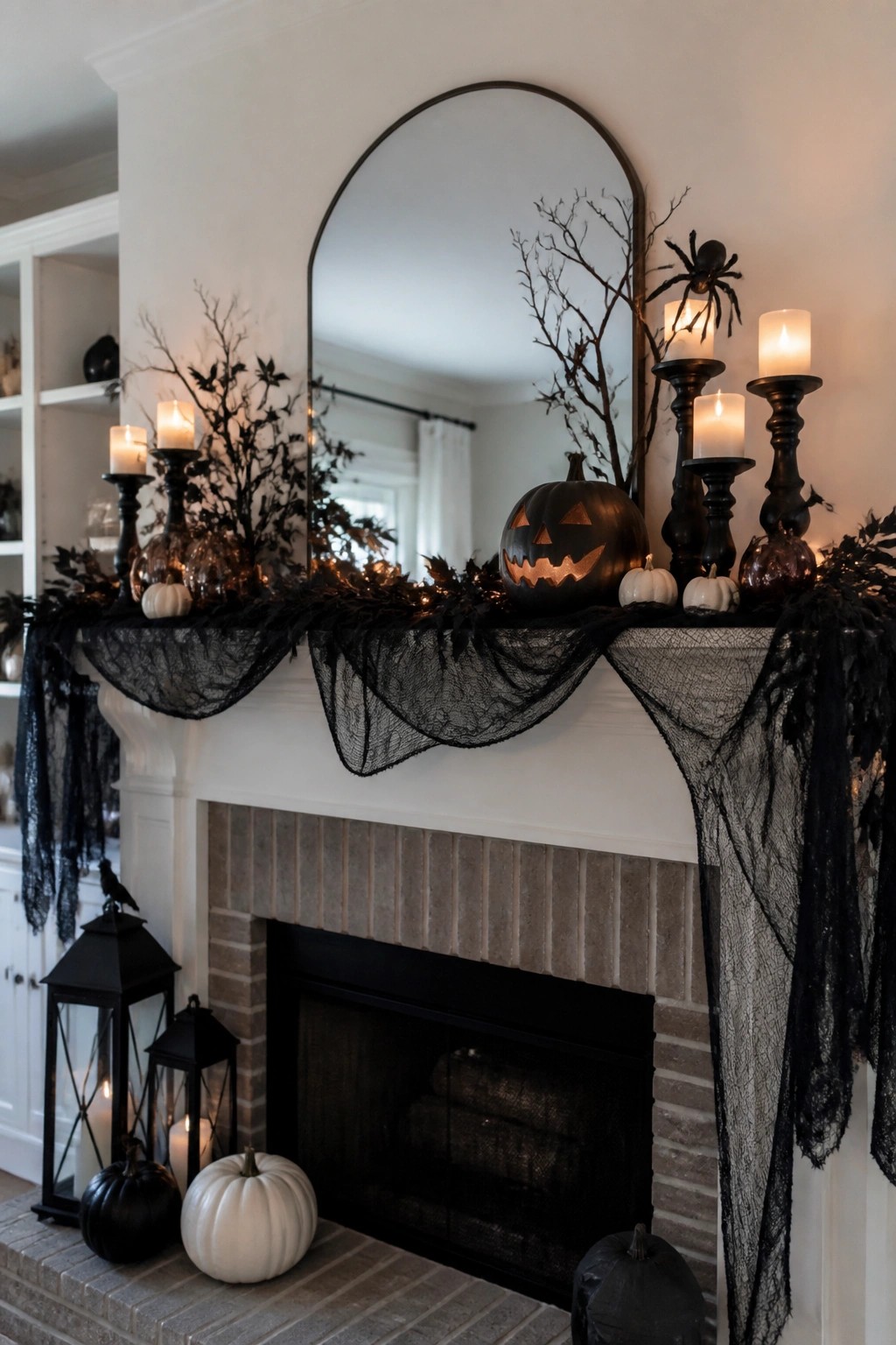 White fireplace mantel decorated for Halloween with a carved jack o lantern, black branches, spiders, candles, and black lace garland.