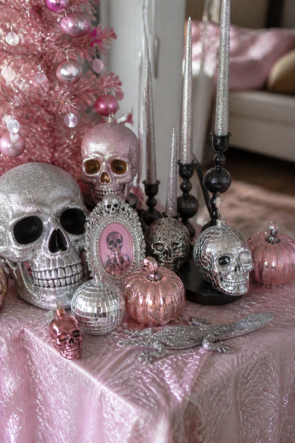 Glittery pink and silver skulls, disco balls, candles, and pumpkins on pink fabric