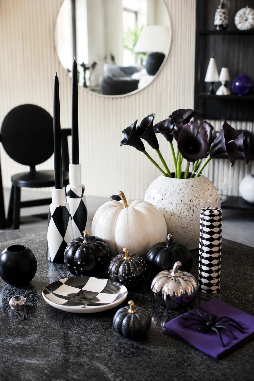 Dark tabletop with black and white checkered candles, pumpkins in different finishes, and a spider on a purple napkin.