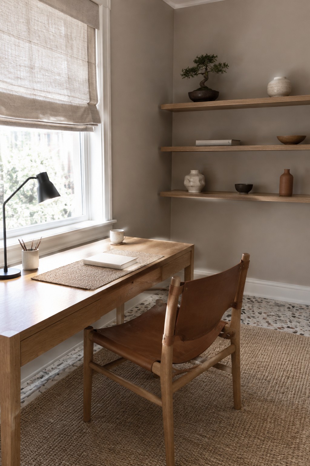 Warm greige study walls with natural oak shelves and a wood desk.