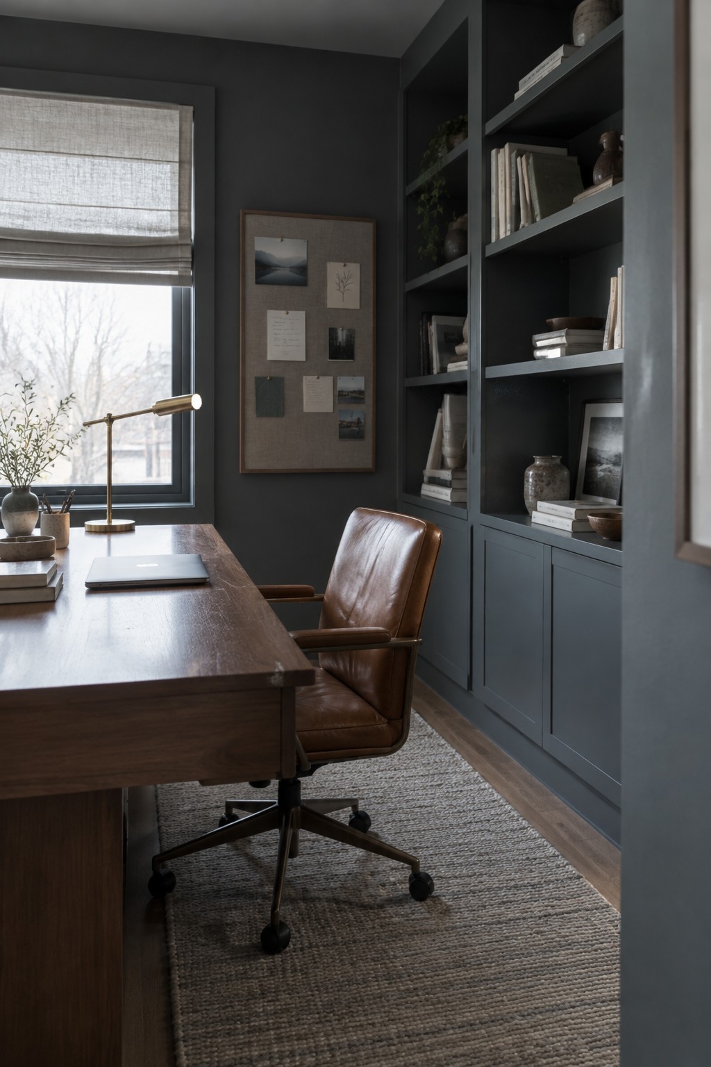 Deep blue-gray paint covers the office walls and built-in bookshelves.