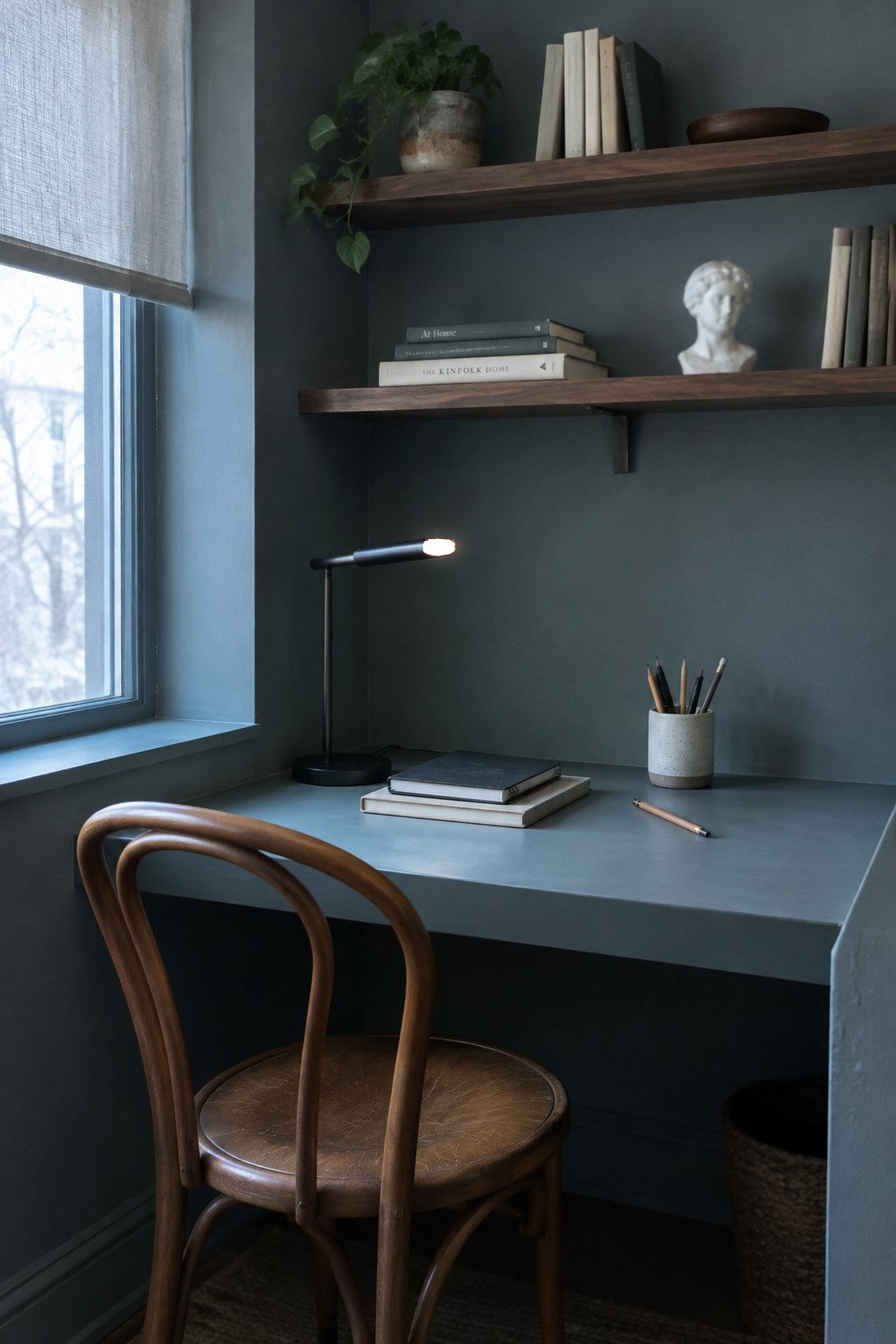 Blue-gray paint covers the walls and desk in a compact home office nook.