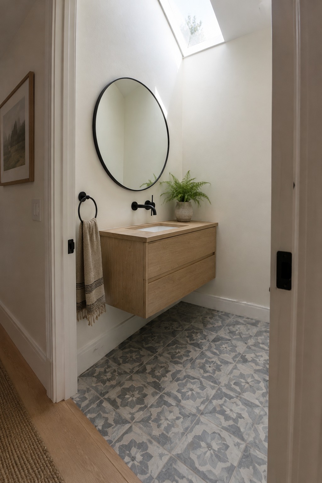 Warm off-white bathroom walls above an oak vanity and patterned floor tile.